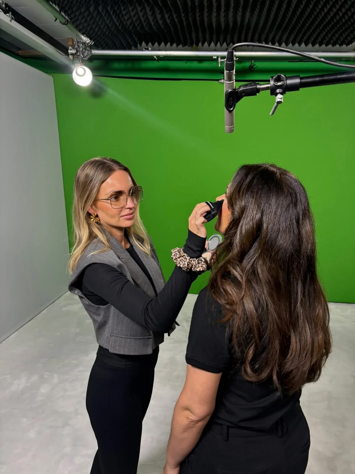 Camilla Edvinsson gör en touch-up framför greenscreen under en inspelning